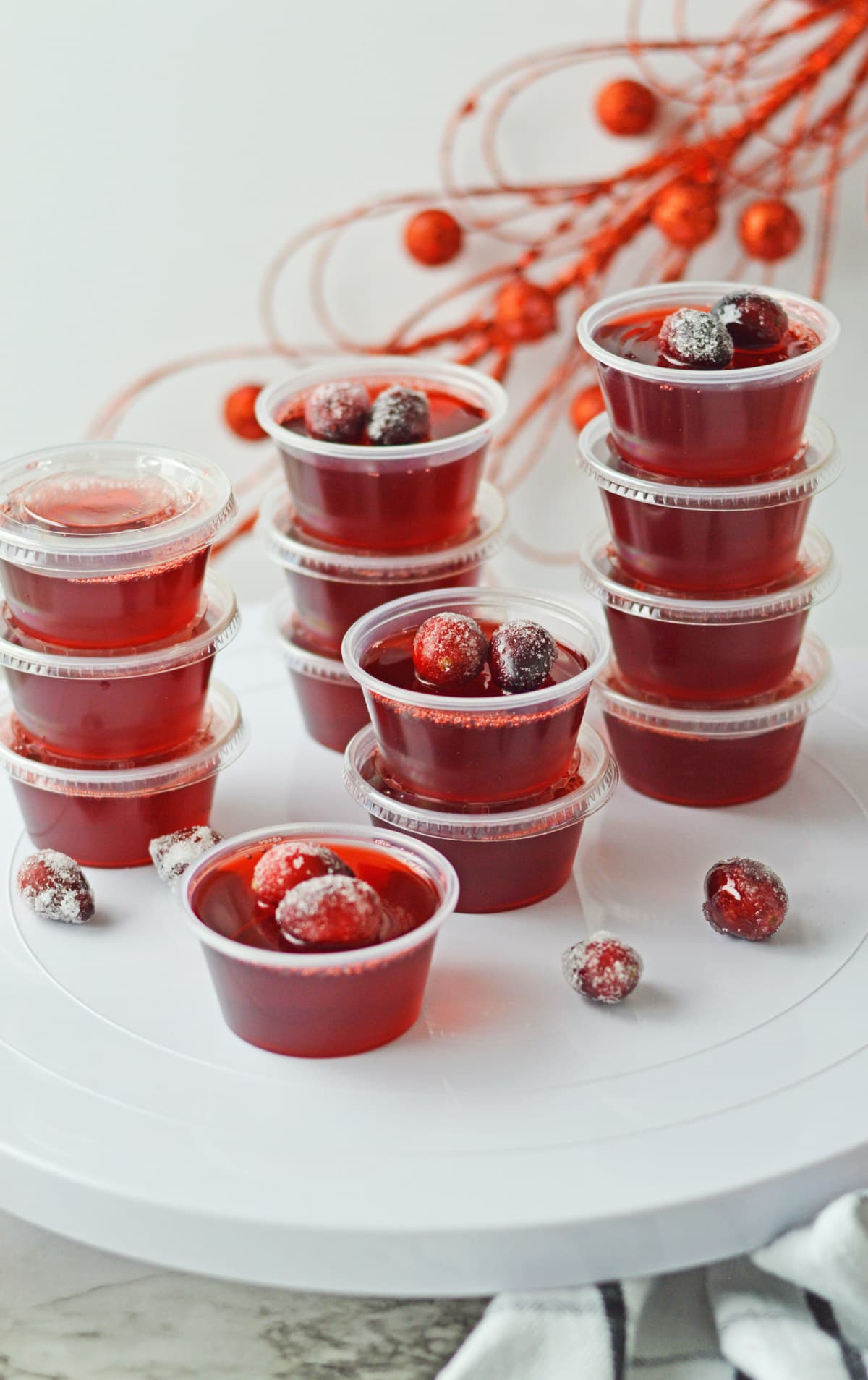 Cranberry jello shots with red decor in background