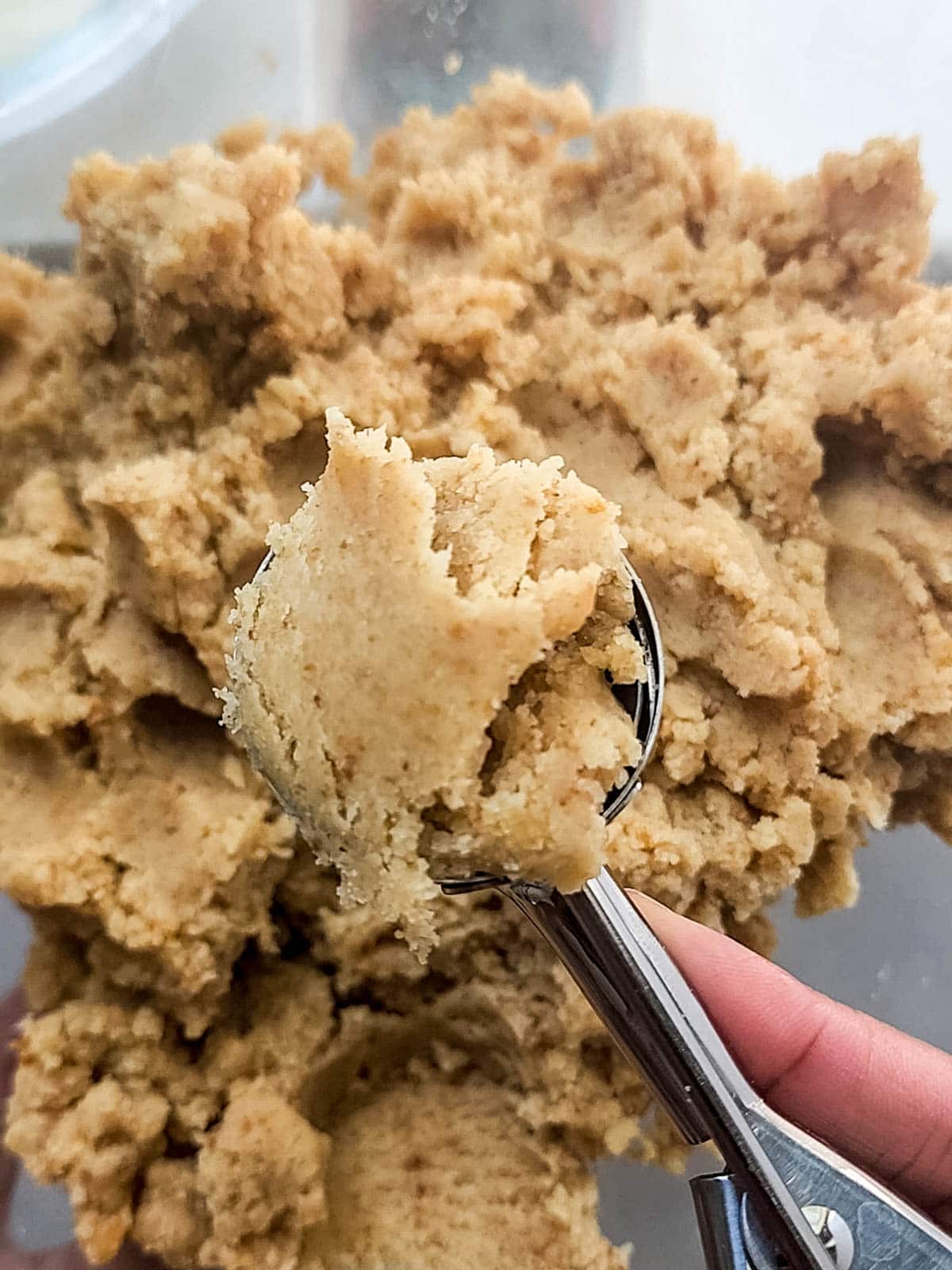 Cake mixed with frosting being scooped with cookie scoop