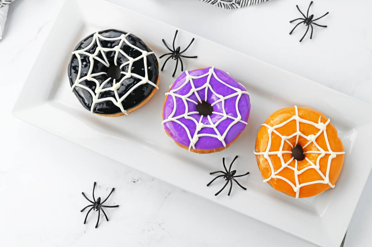 Halloween donuts on white plate with plastic spiders