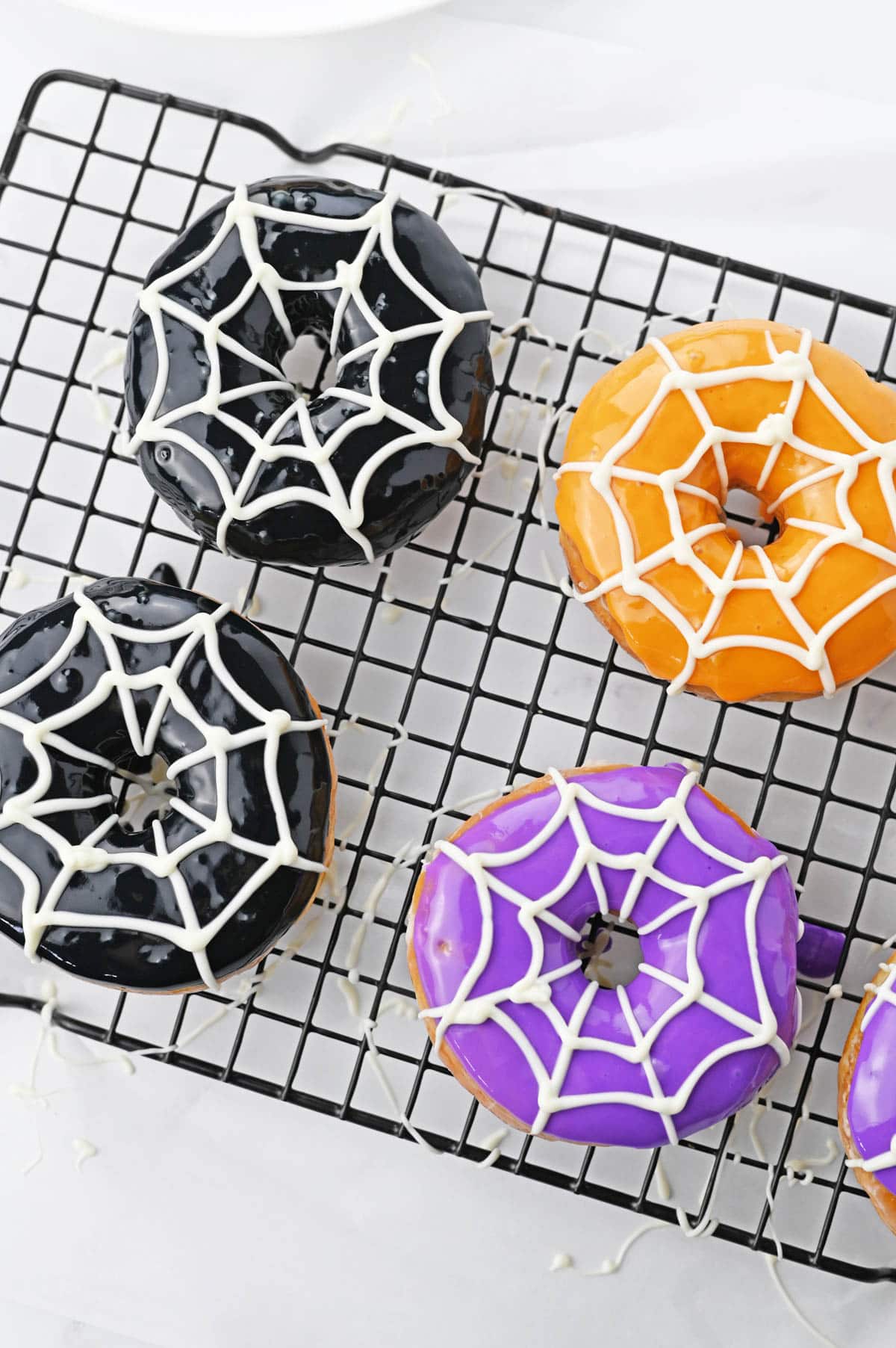 Donuts decorated with white chocolate to look like a spiderweb