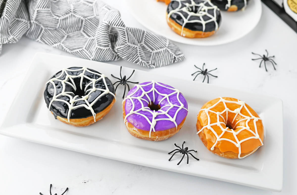Spiderweb pumpkins on white plate with black spiders