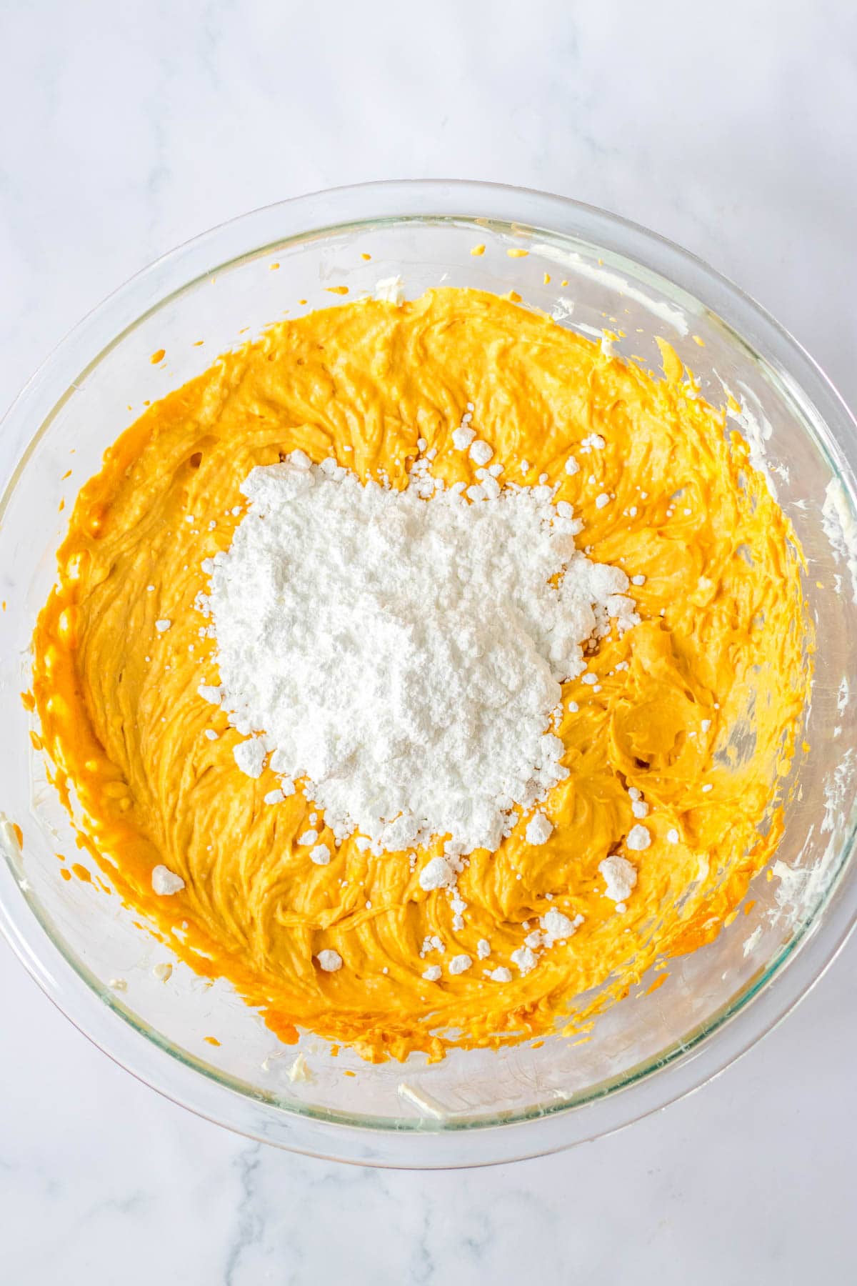 Powdered sugar in mixing bowl with pumpkin puree mixture