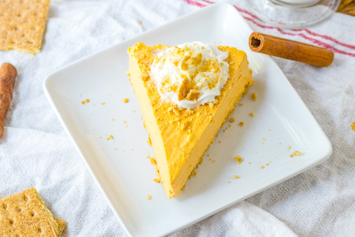 Pumpkin cheesecake with whipped cream and cinnamon stick