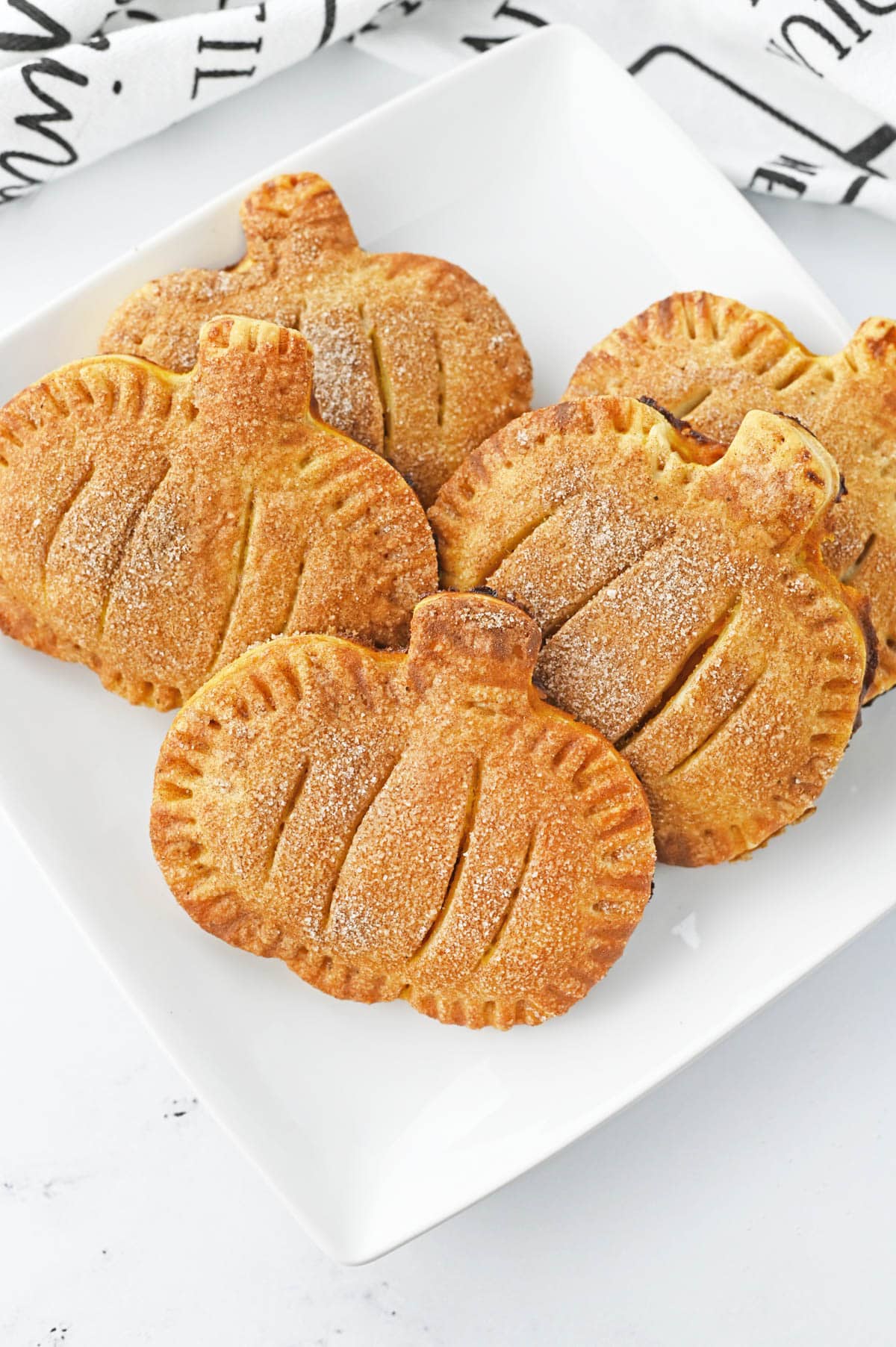 Pumpkin shaped hand pies on white plate