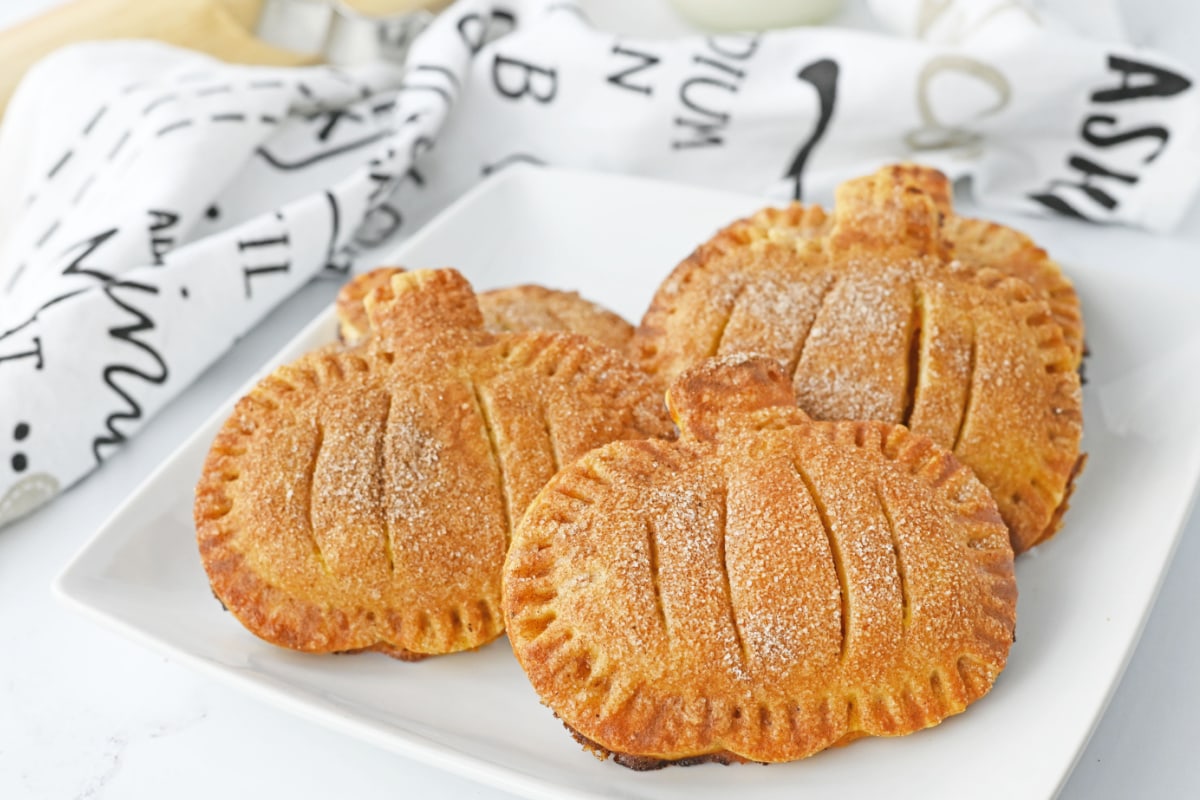 Pumpkin hand pies on white plate with black and white napkin