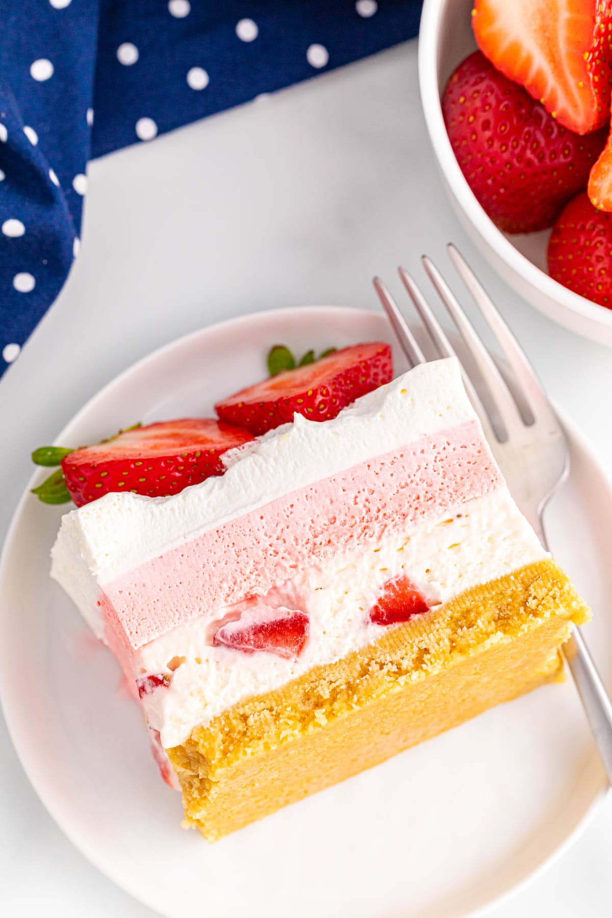 Slice of strawberry cheesecake lush on white plate
