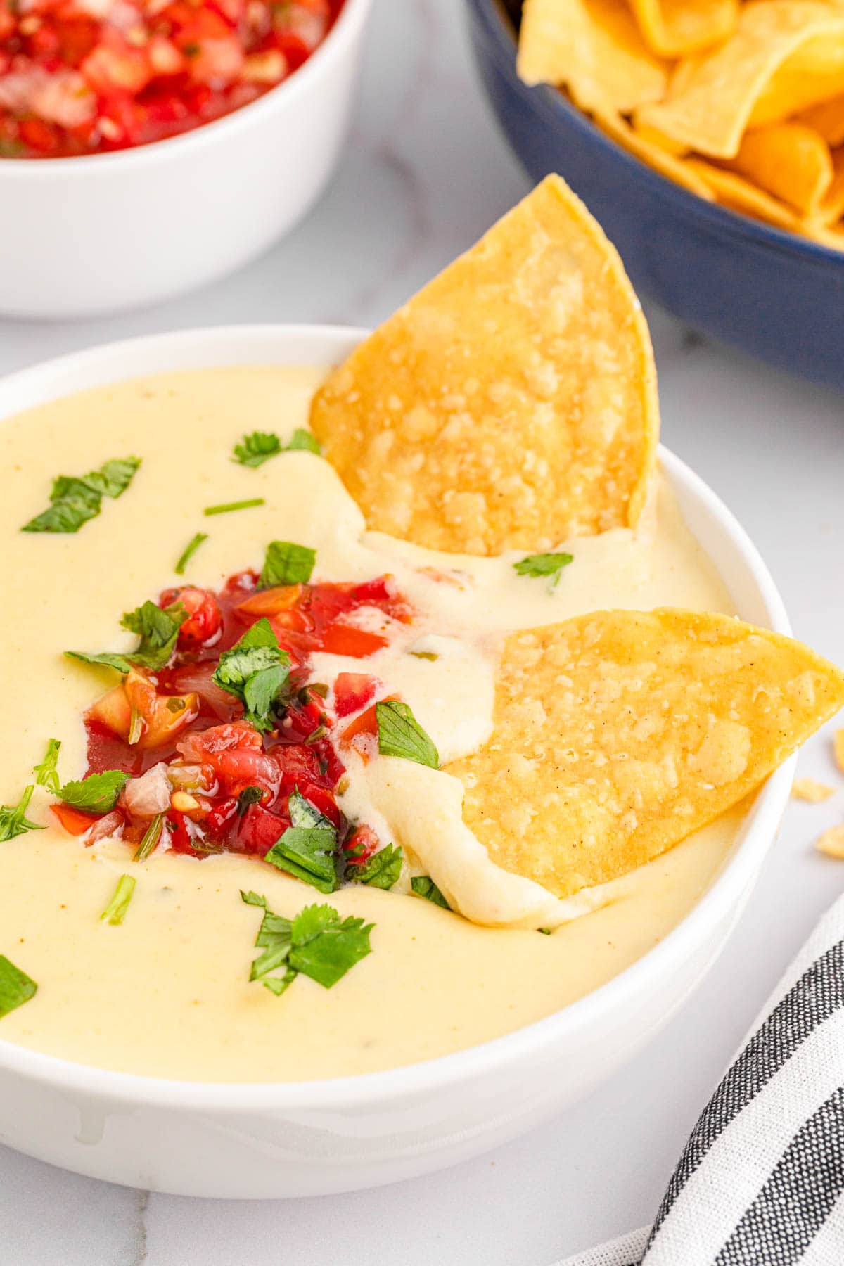Chips dipped into queso dip