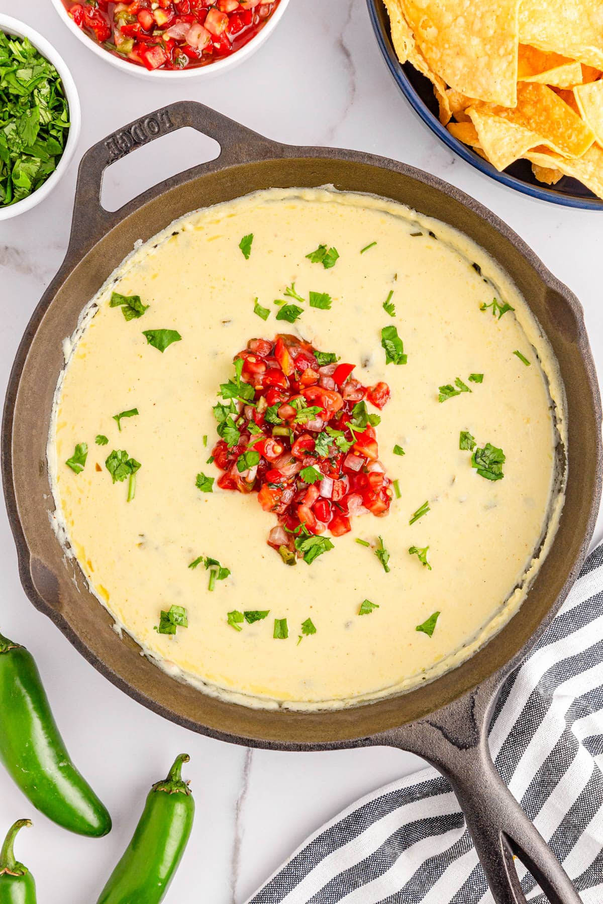 Queso dip with diced tomatoes and cilantro