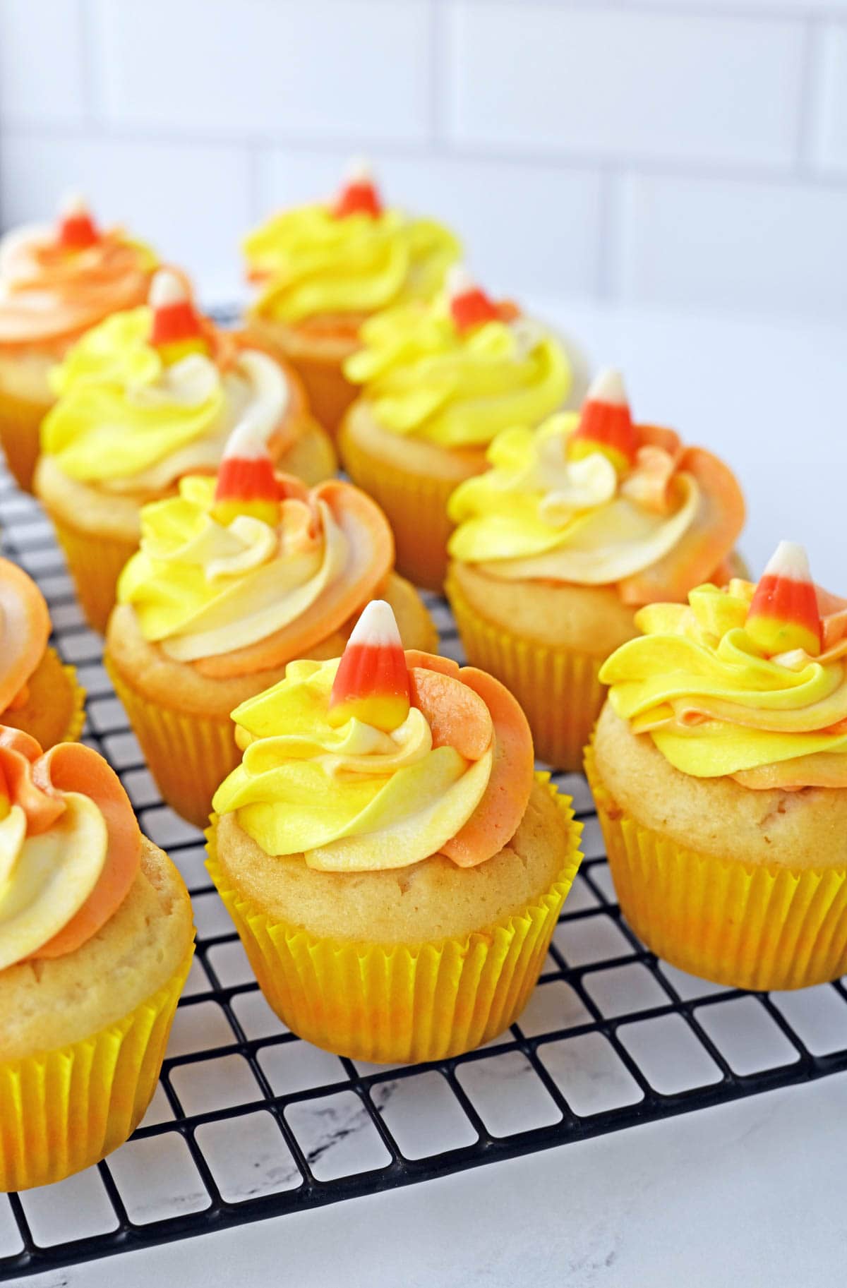 Cupcakes topped with orange, yellow and white swirled icing
