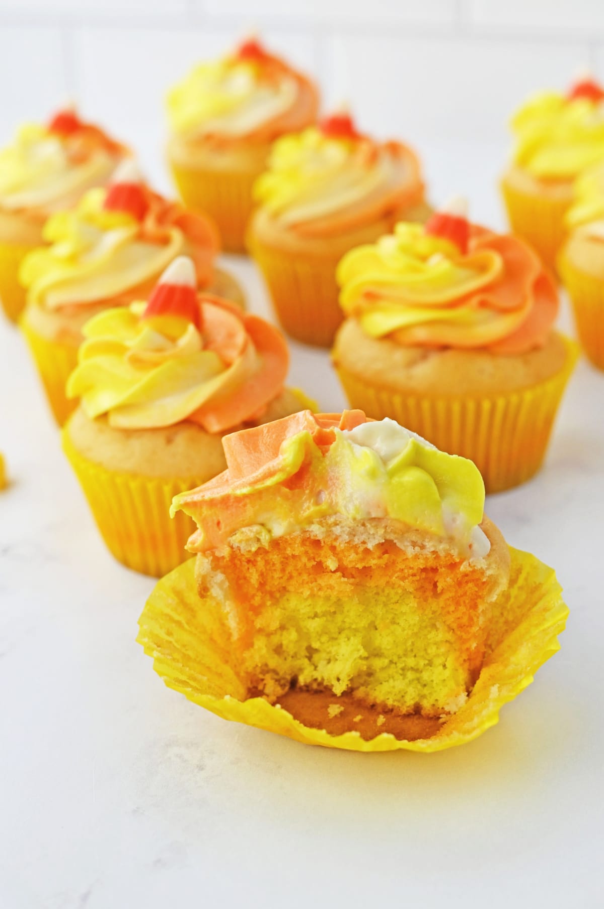 Half of a candy corn cupcake in liner