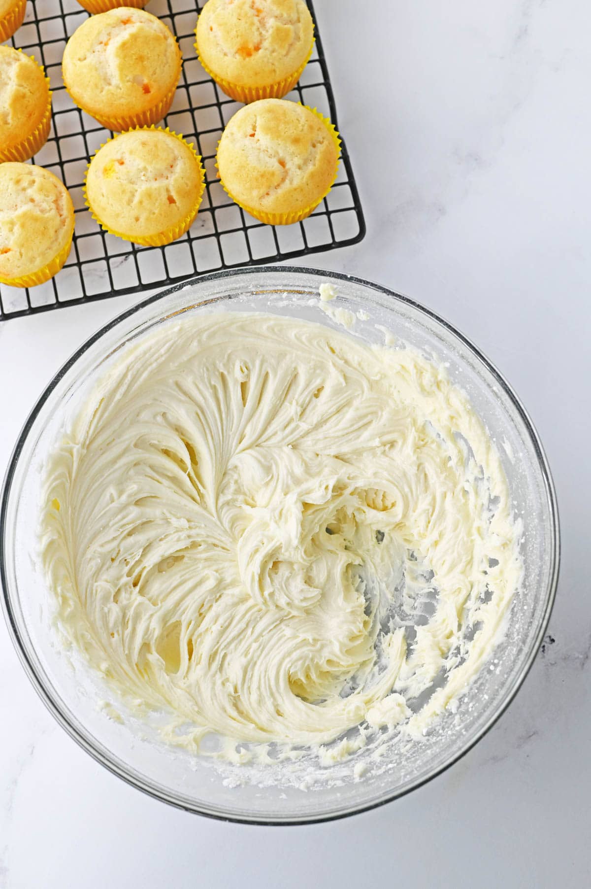 Buttercream frosting in clear glass bowl