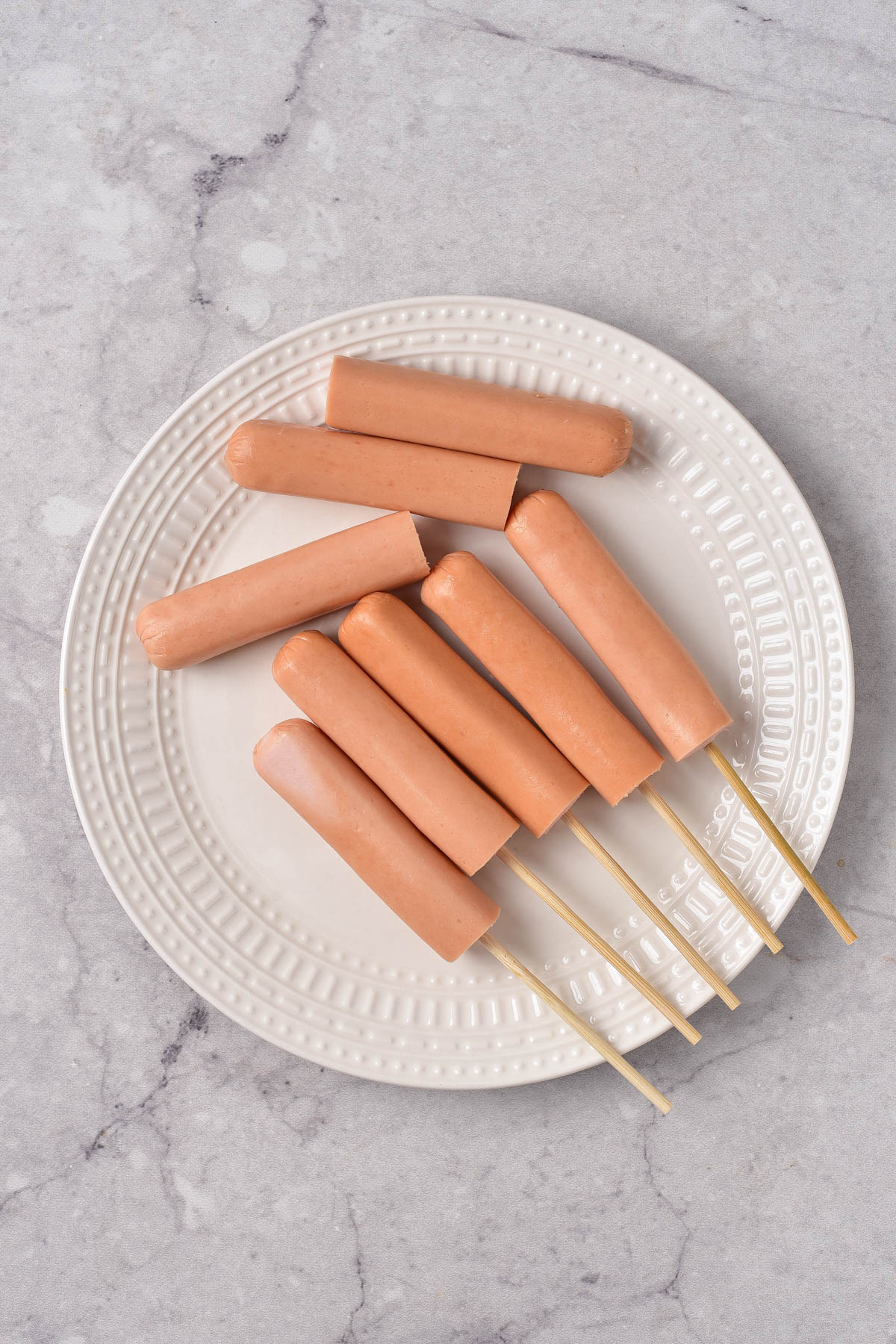 Hot dogs on sticks on plate