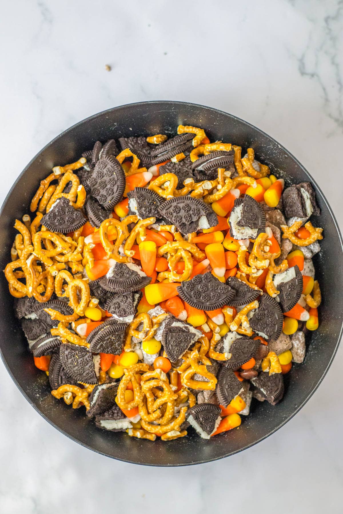 Puppy chow topped with candy corn, pretzels and cookies