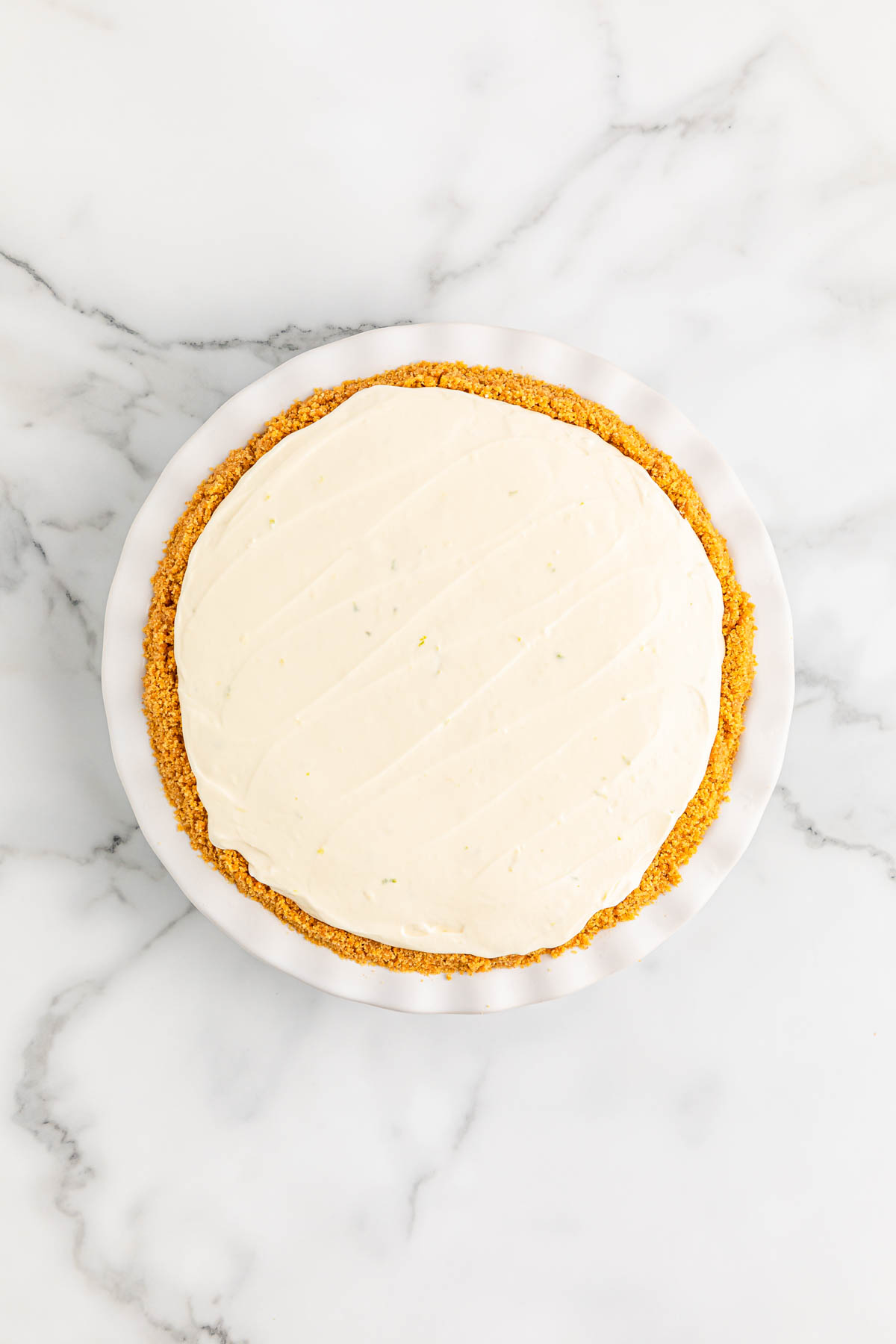 Key lime pie in a white pie dish