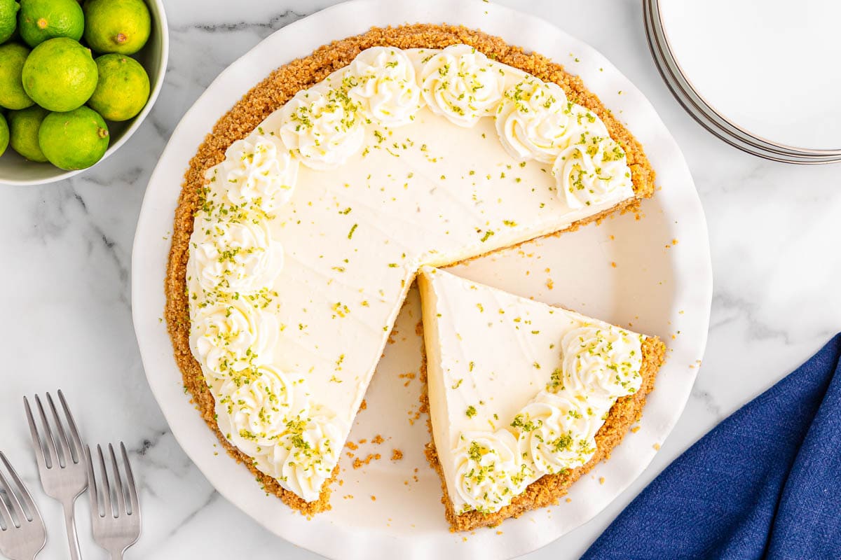 Key lime pie from above with a bowl of key limes