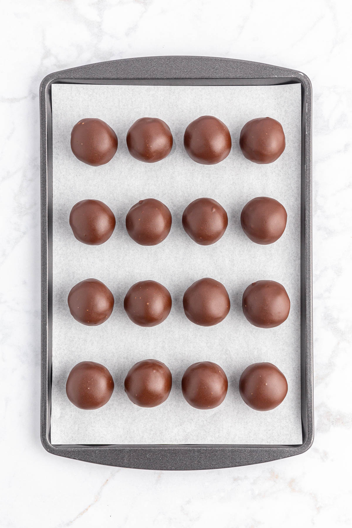 Chocolate peanut butter balls on baking sheet