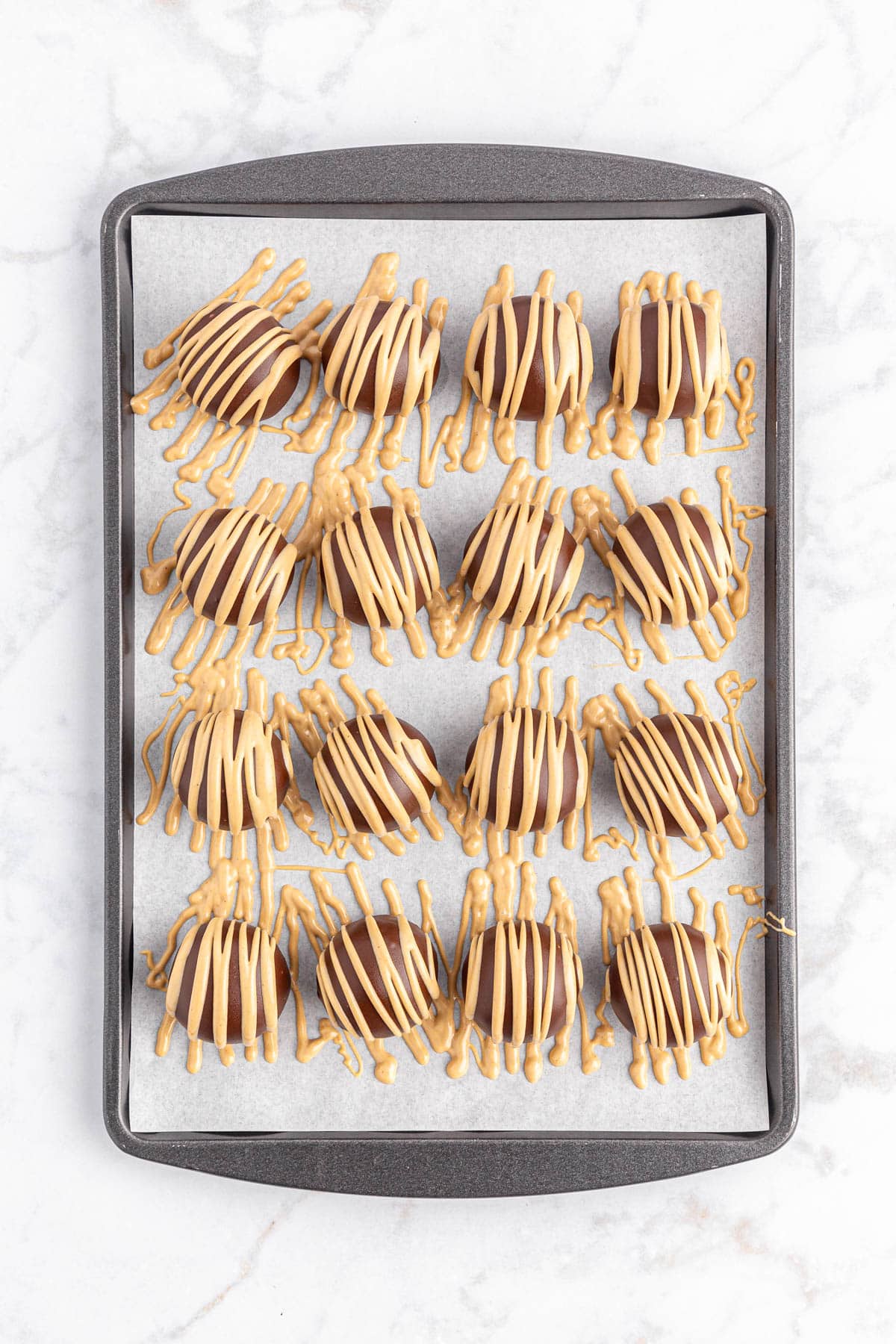 Chocolate peanut butter balls drizzled with peanut butter mixture