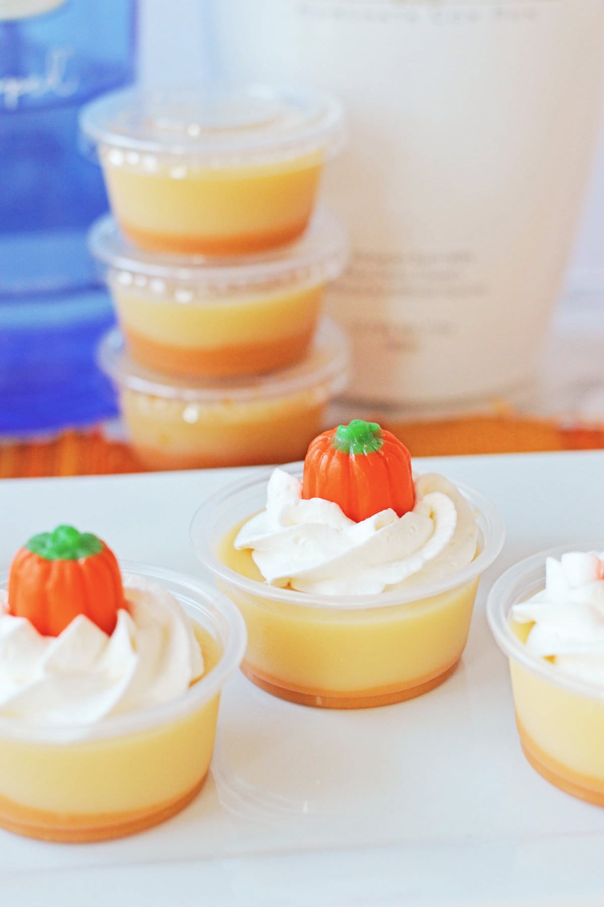 Pumpkin Jello Shots with stacked shots in background