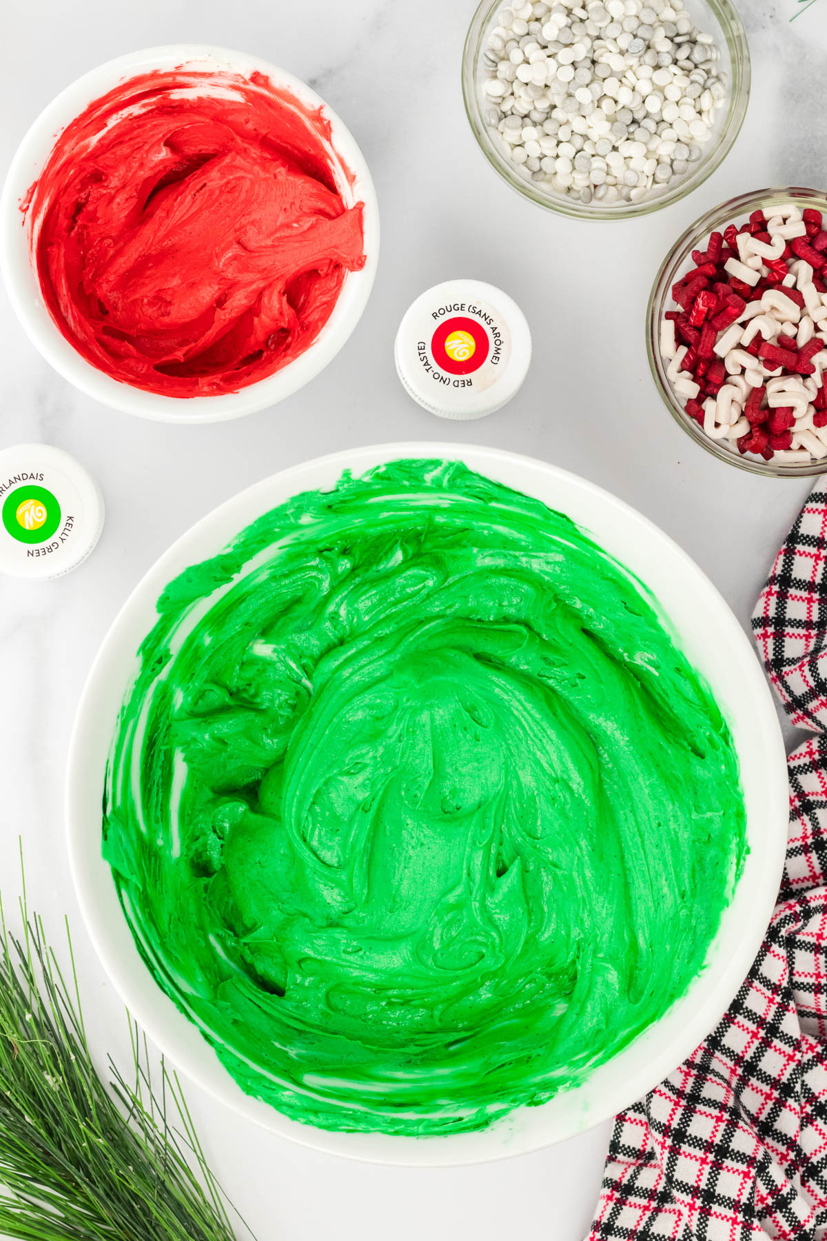 A bowl of green, red, and white icing.