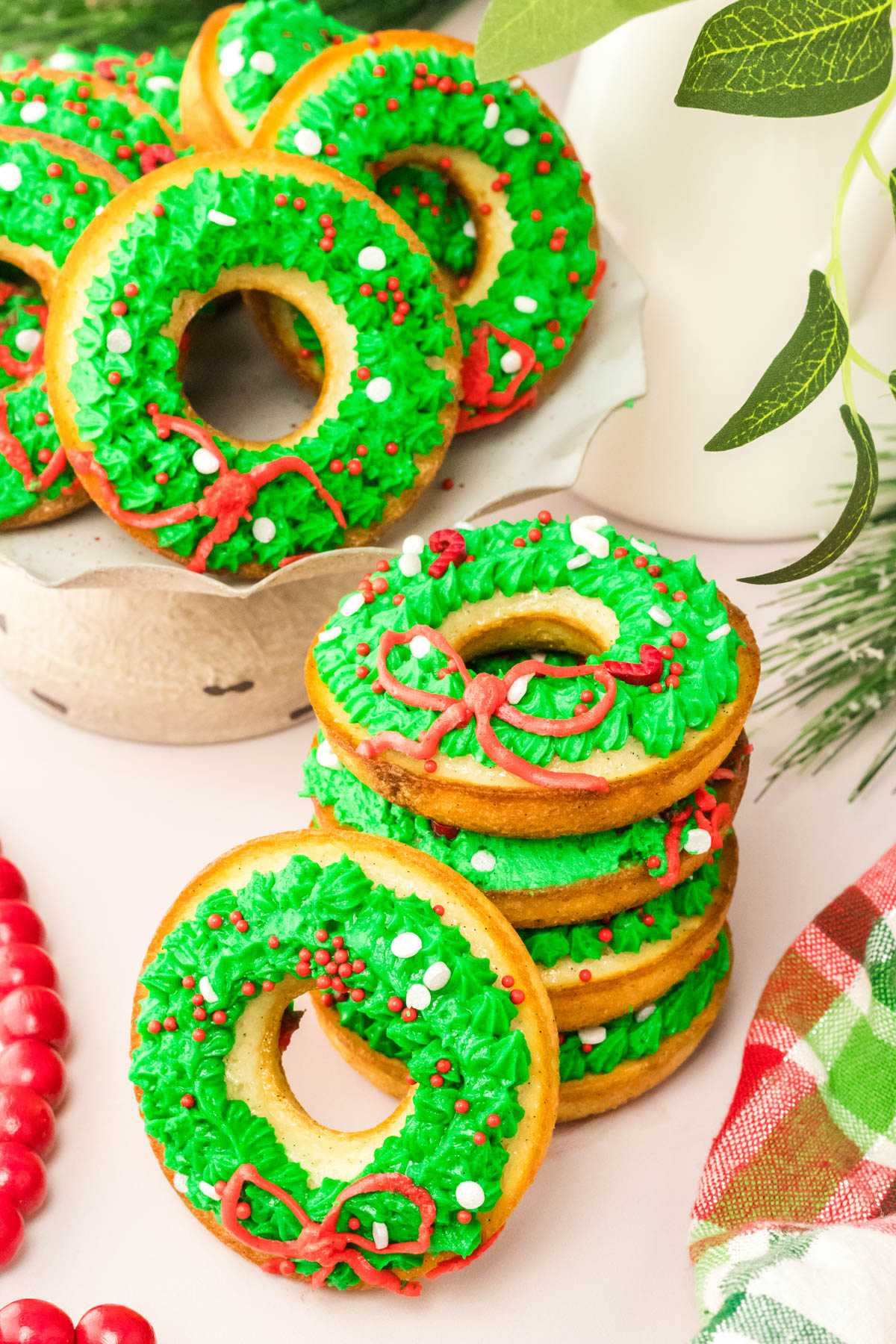 A plate of donuts decorated with green and red icing.