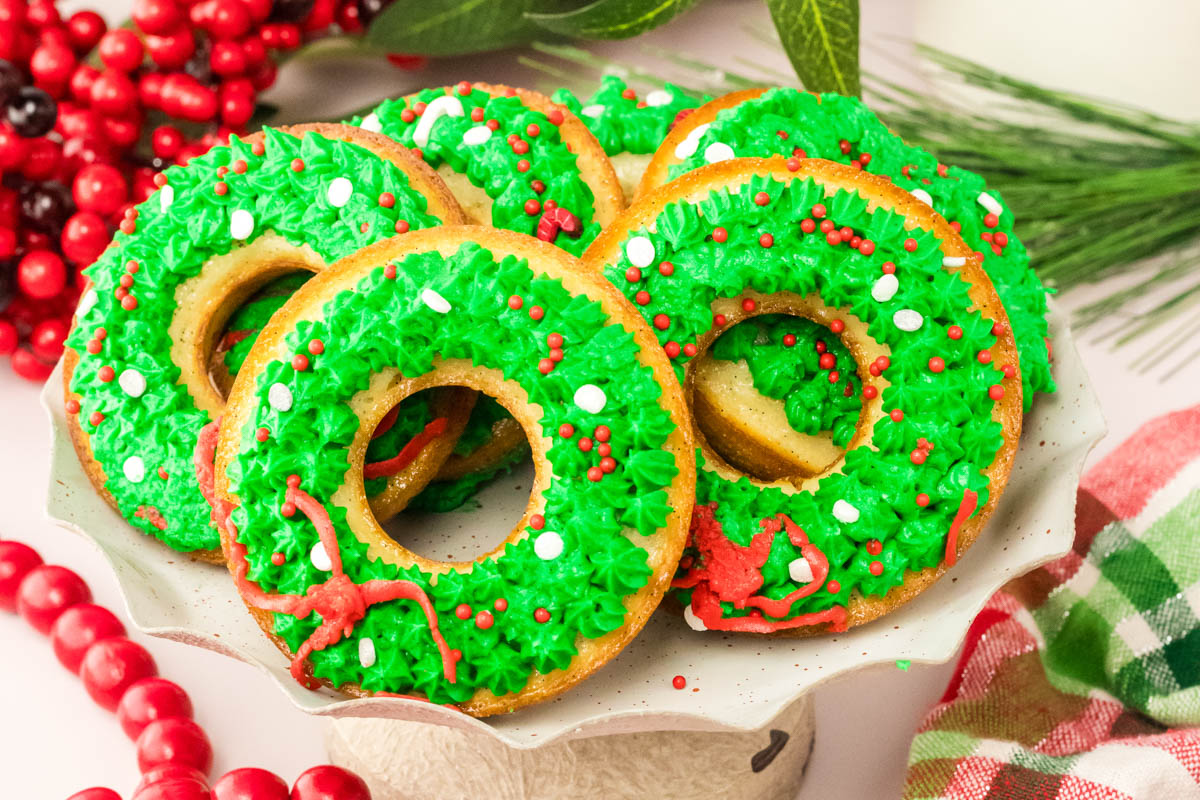 Donuts decorated with green and red icing on a plate.