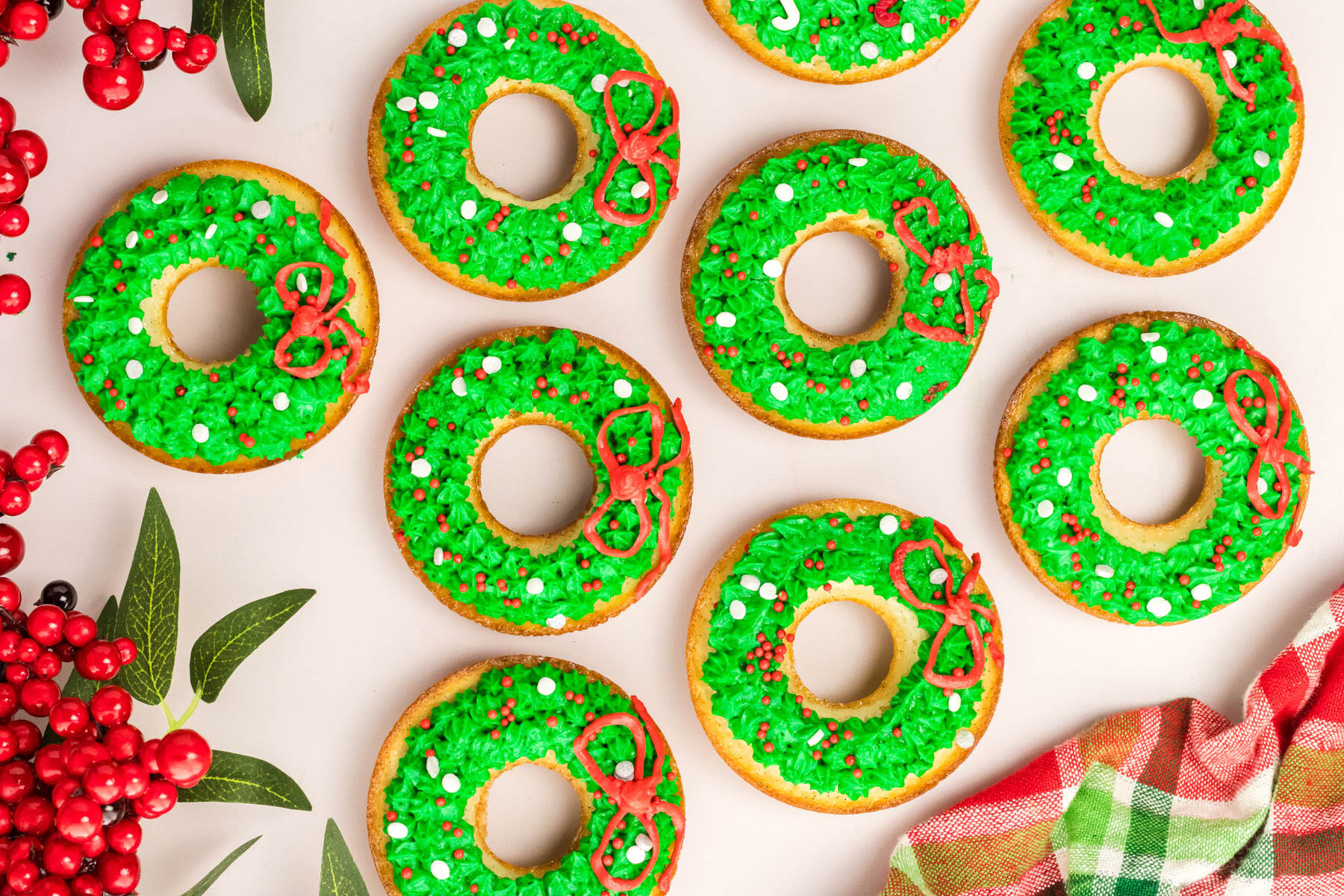 Donuts decorated with christmas wreaths and berries.