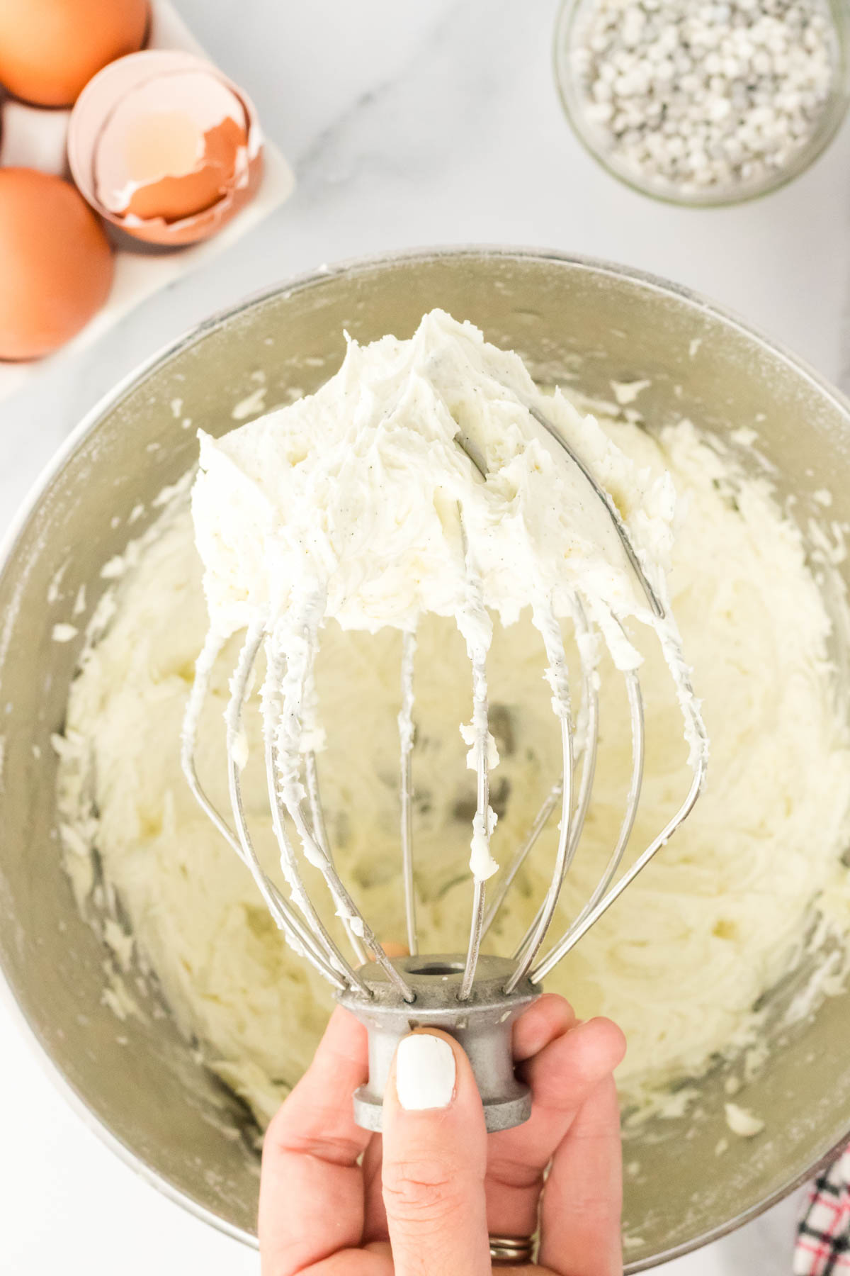 A person using a whisk to make frosting