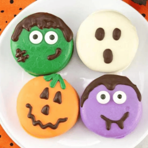 Four halloween shaped cookies on a plate.
