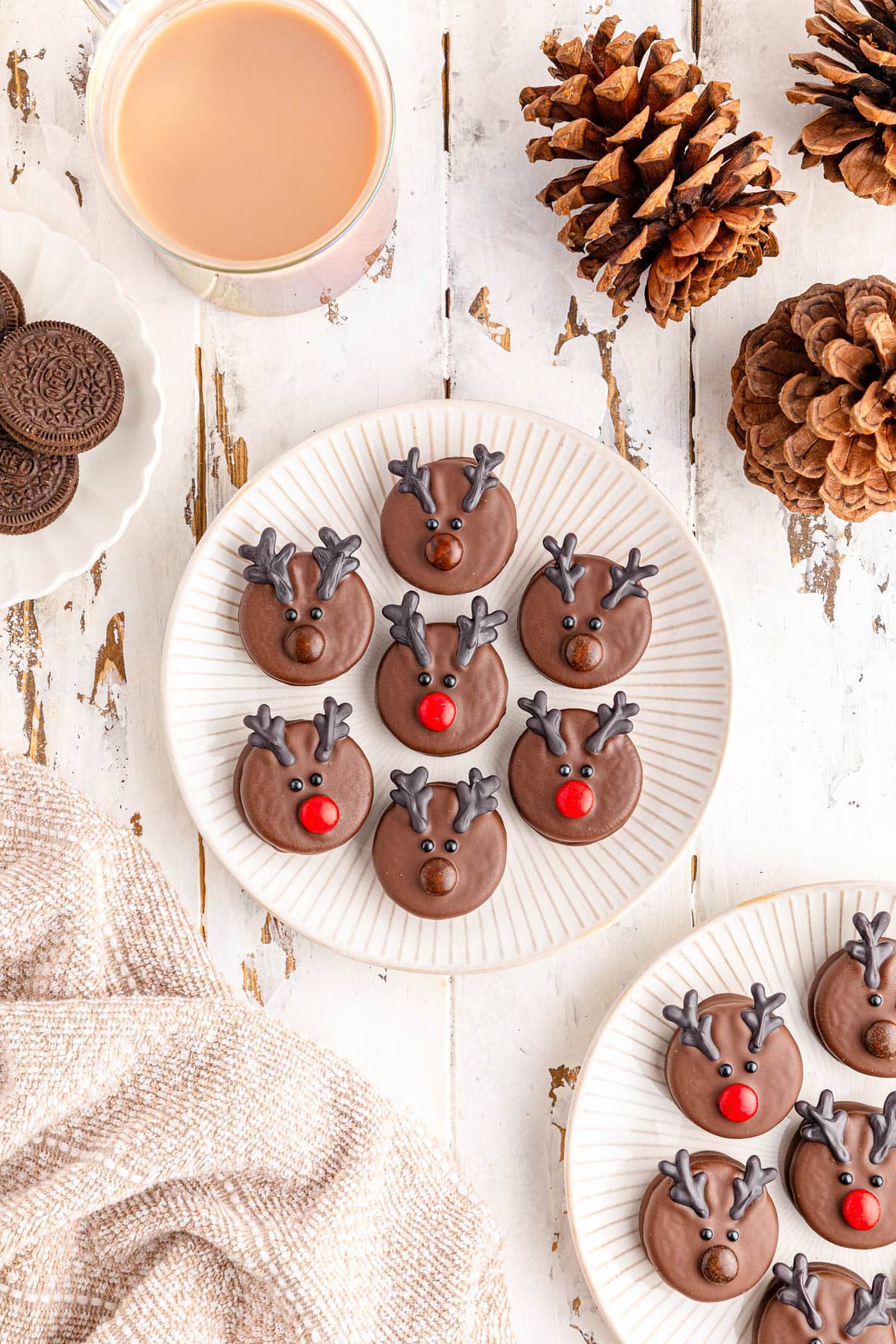 Chocolate reindeer cookies on a white table with a cup of coffee.