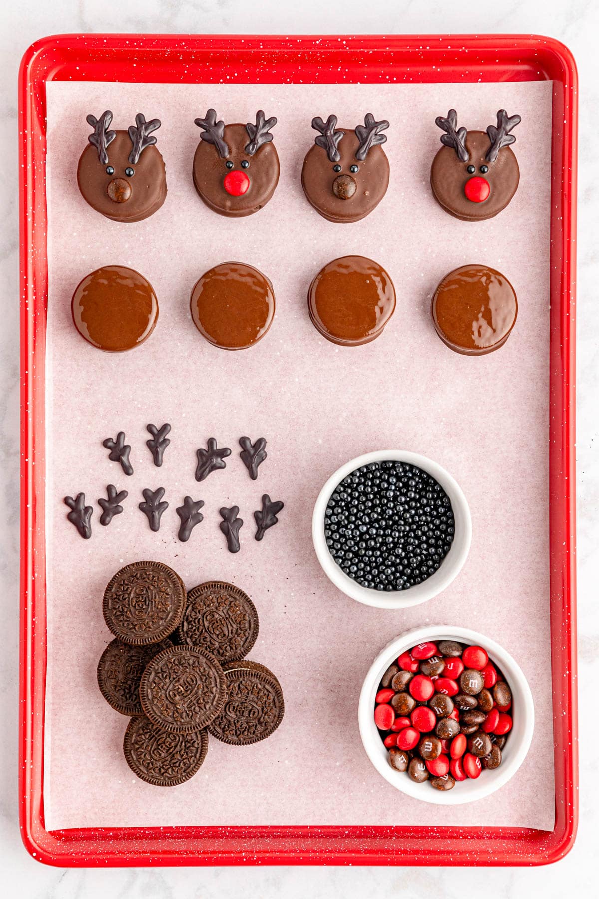 Chocolate reindeer cookies on a red tray.