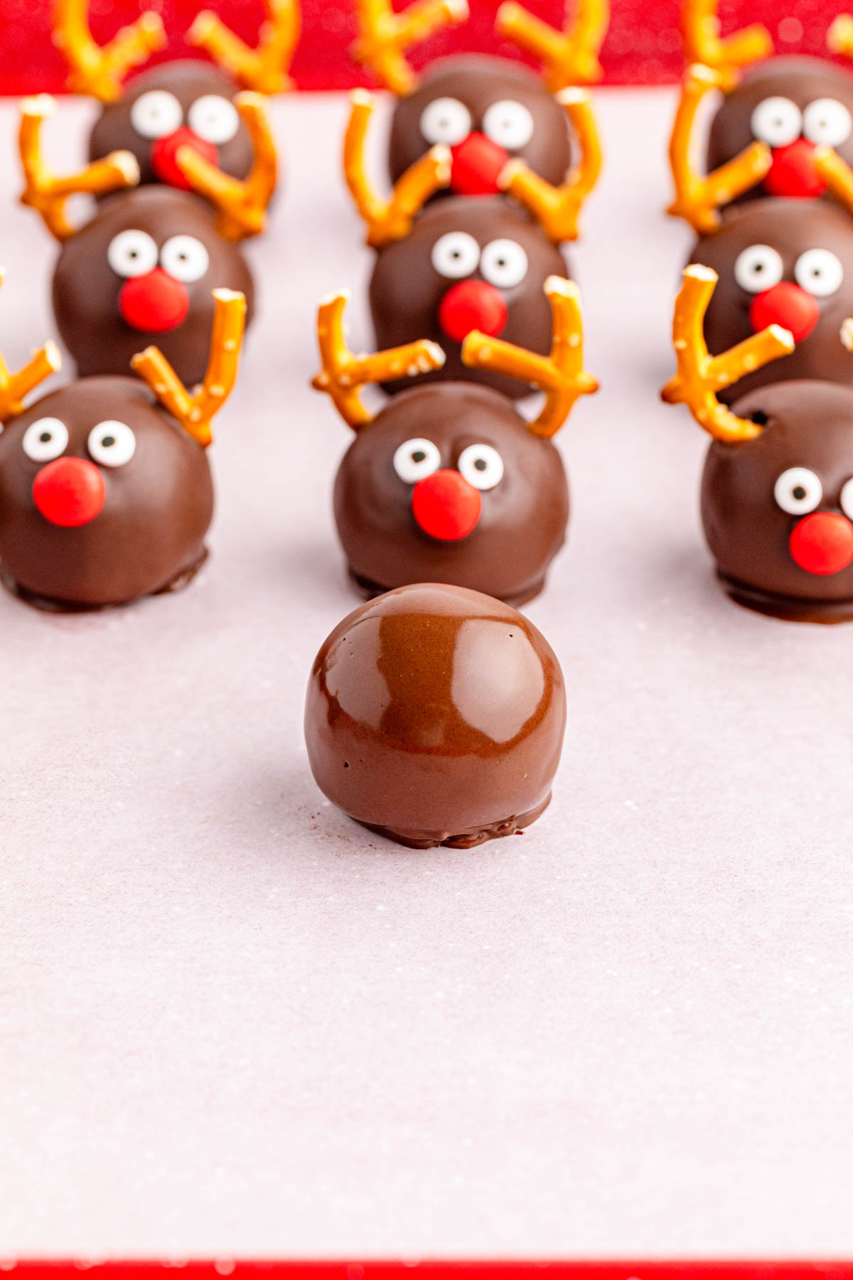 Chocolate reindeer truffles on a red background.