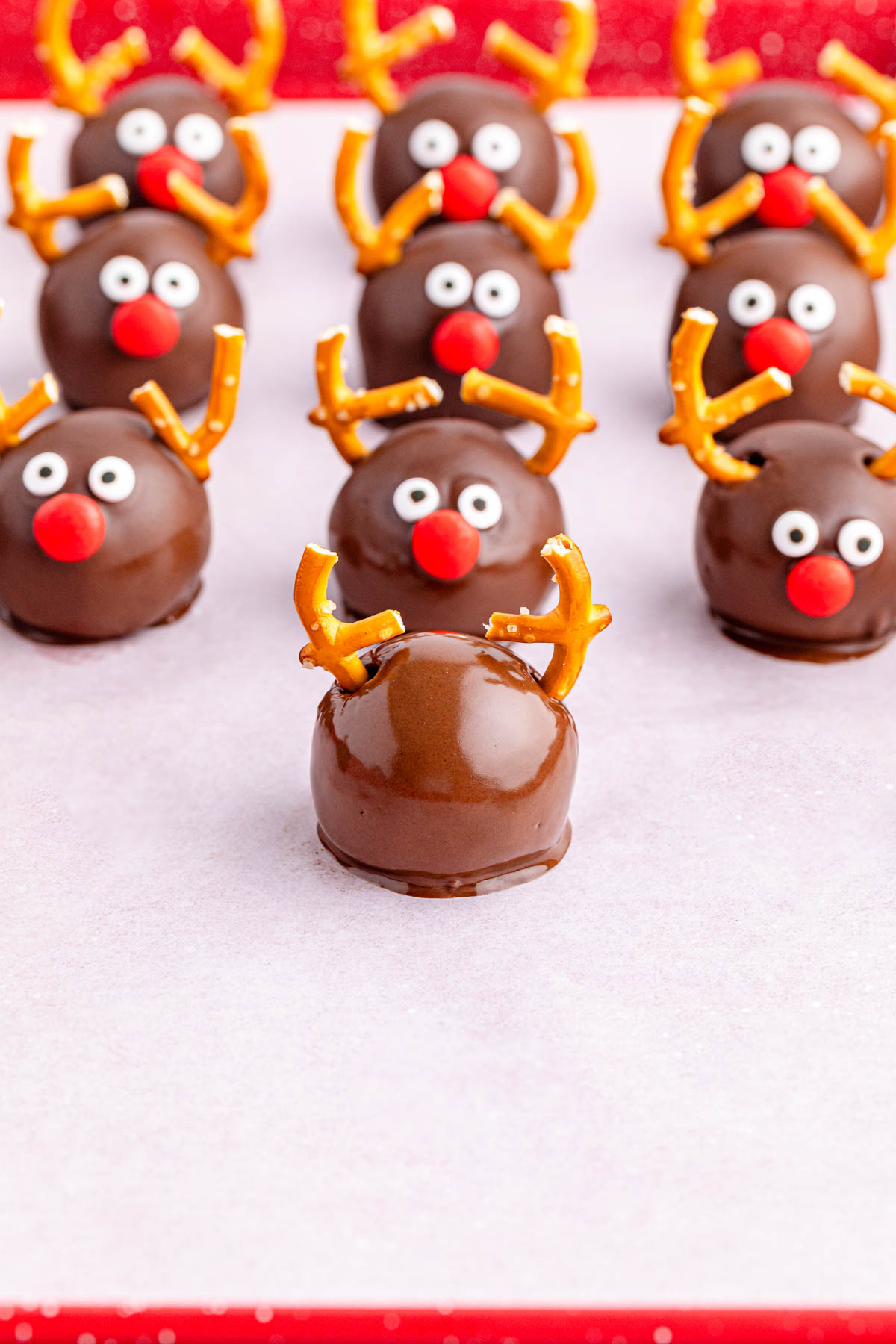 Chocolate reindeer balls on a red background.
