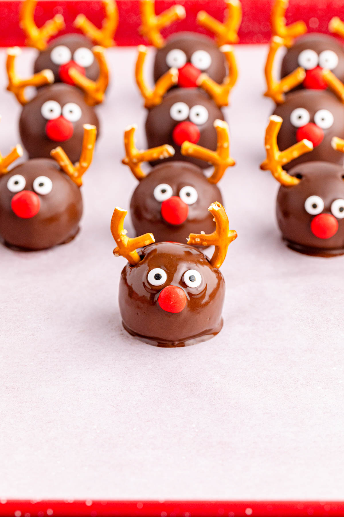 Chocolate reindeer balls on a red plate.