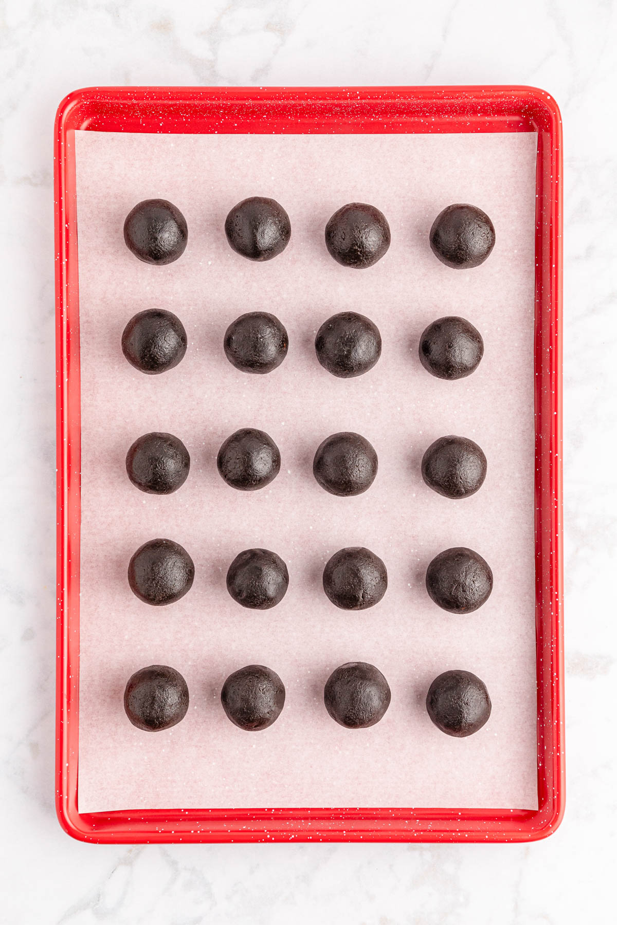A tray of oreo balls on a marble countertop.