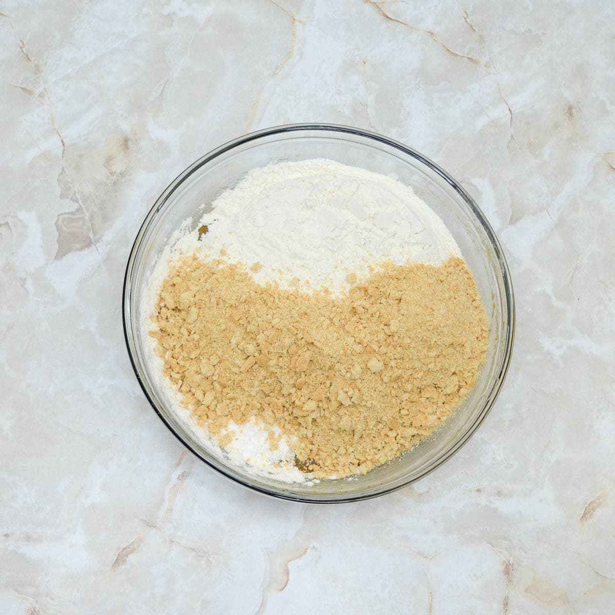 A bowl with graham cracker crumbs and flour in it