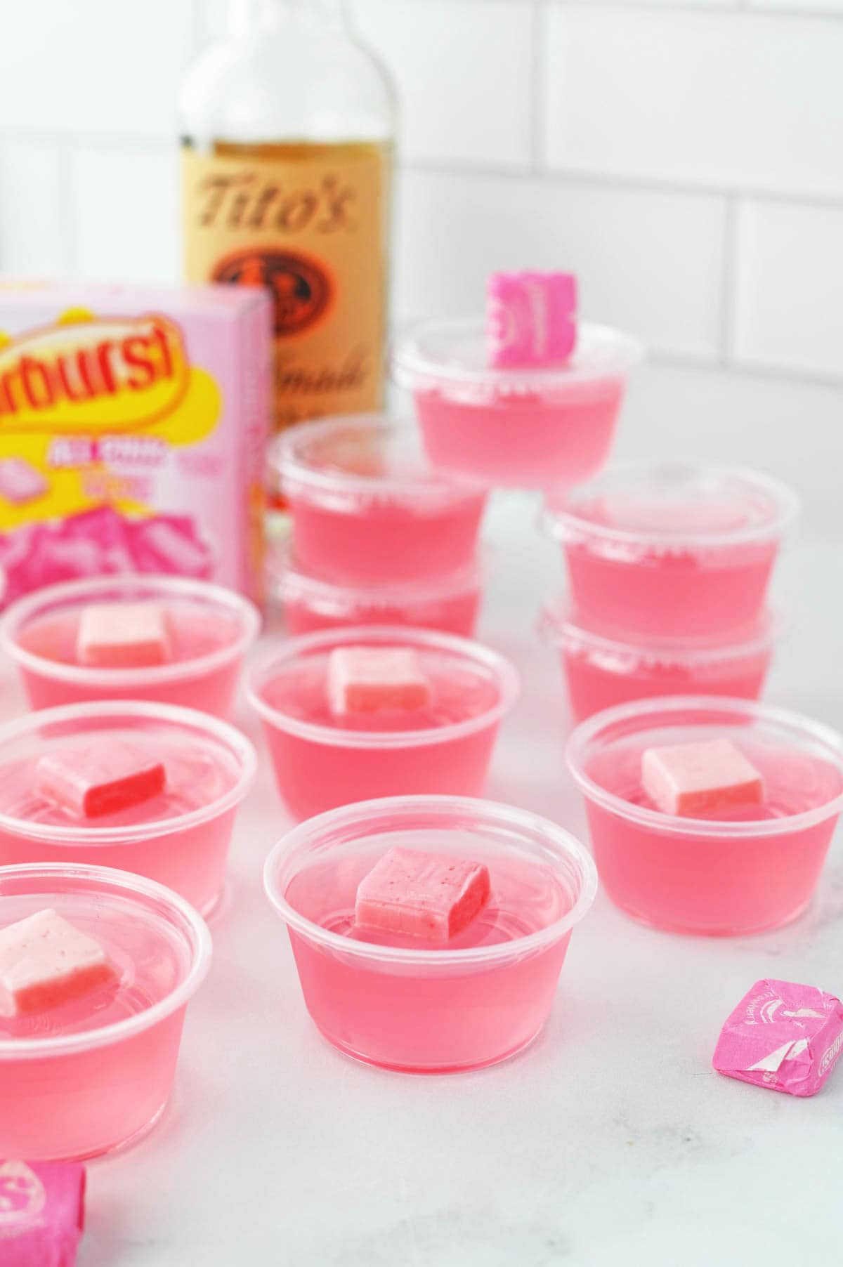 A group of pink jello shots on a counter.