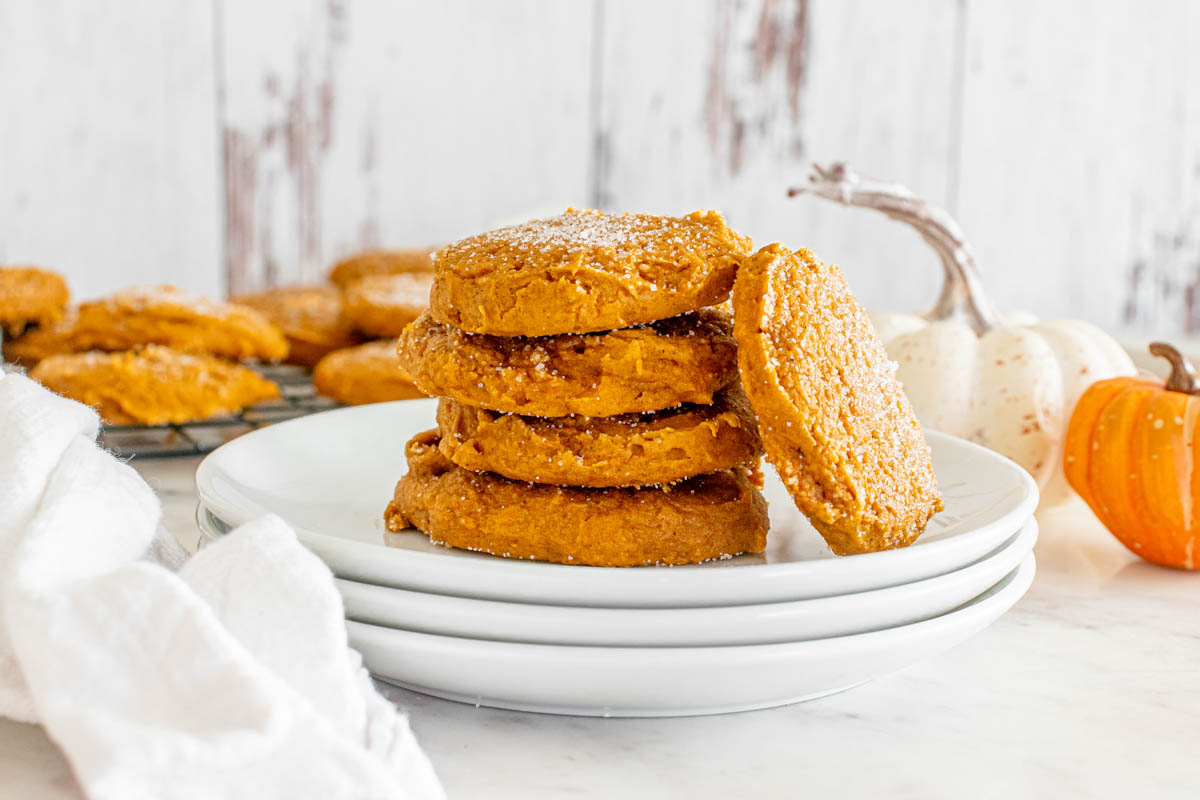 A stack of pumpkin cookies on a white plate.