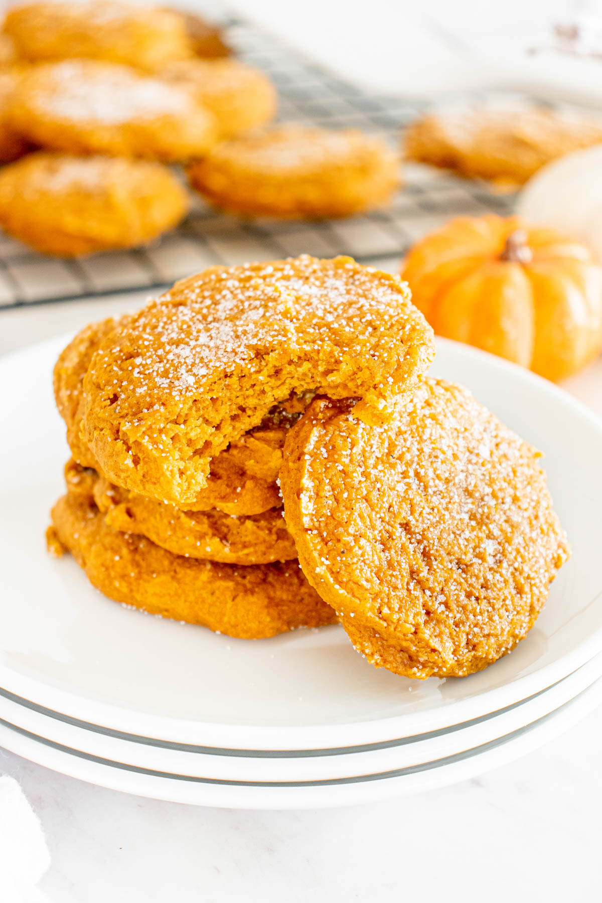 A stack of pumpkin cookies on a plate.