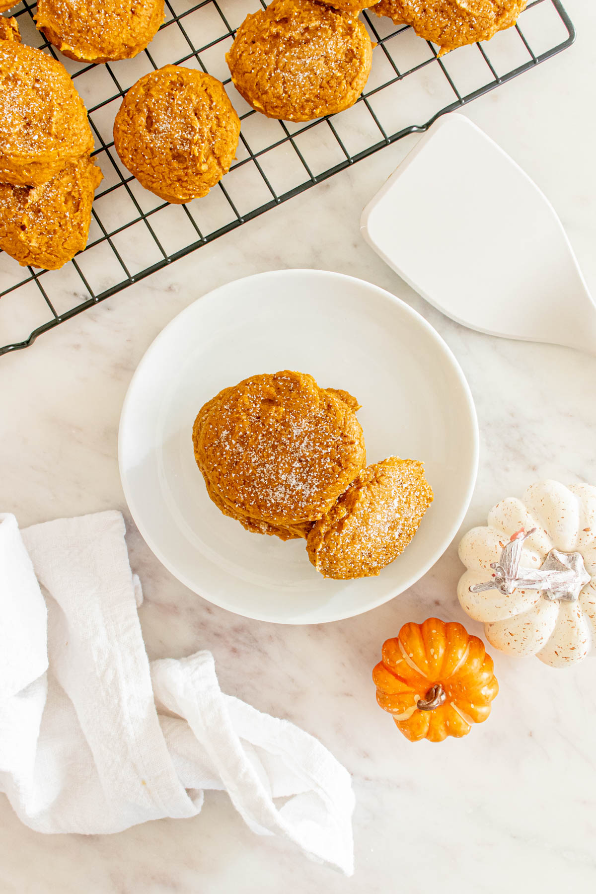 A plate of pumpkin cookies on a marble countertop.