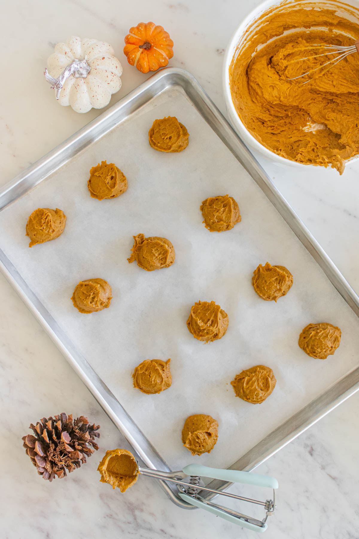 A baking sheet with pumpkin cookies on it.