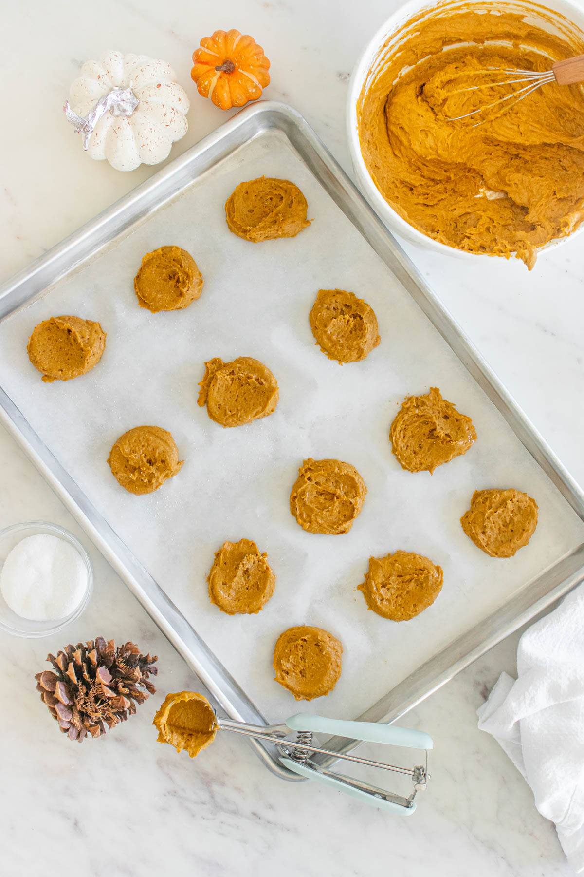 A baking sheet with pumpkin cookie dough on it.