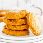 A stack of pumpkin cookies on a white plate.