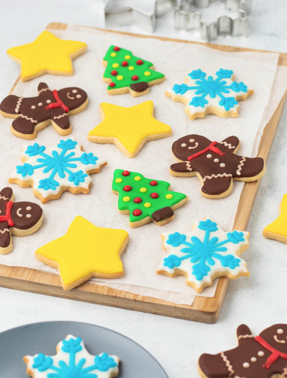 A tray of decorated christmas cookies on a cutting board.