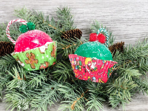 Two cupcake ornaments on a festive Christmas tree.