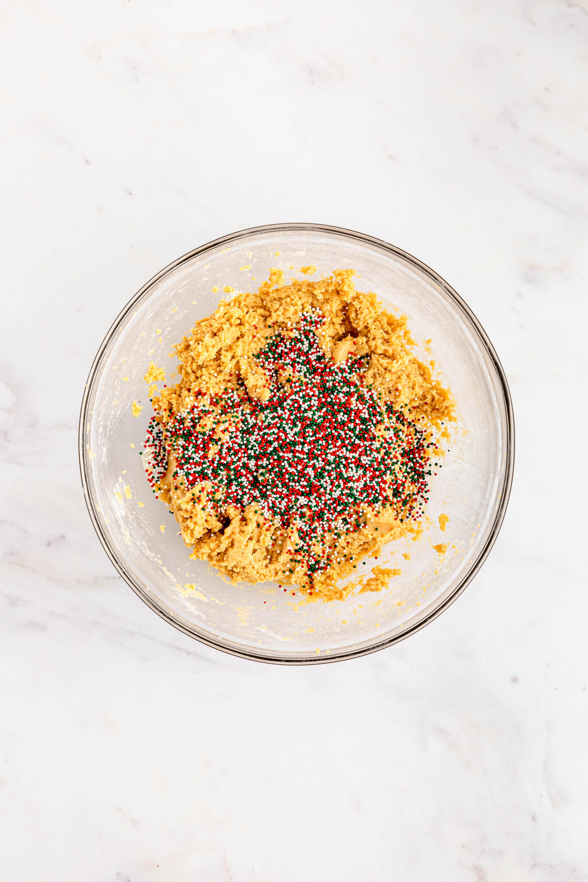 A bowl filled with a mixture of dough and sprinkles.