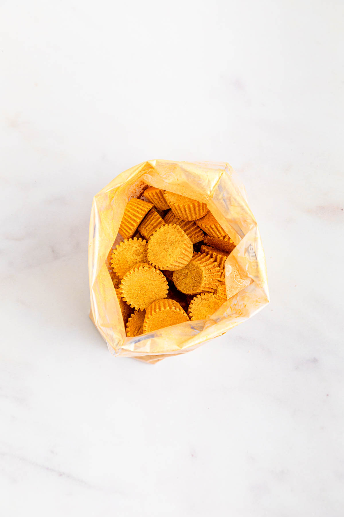 A bag filled with gold Reeses peanut butter minis