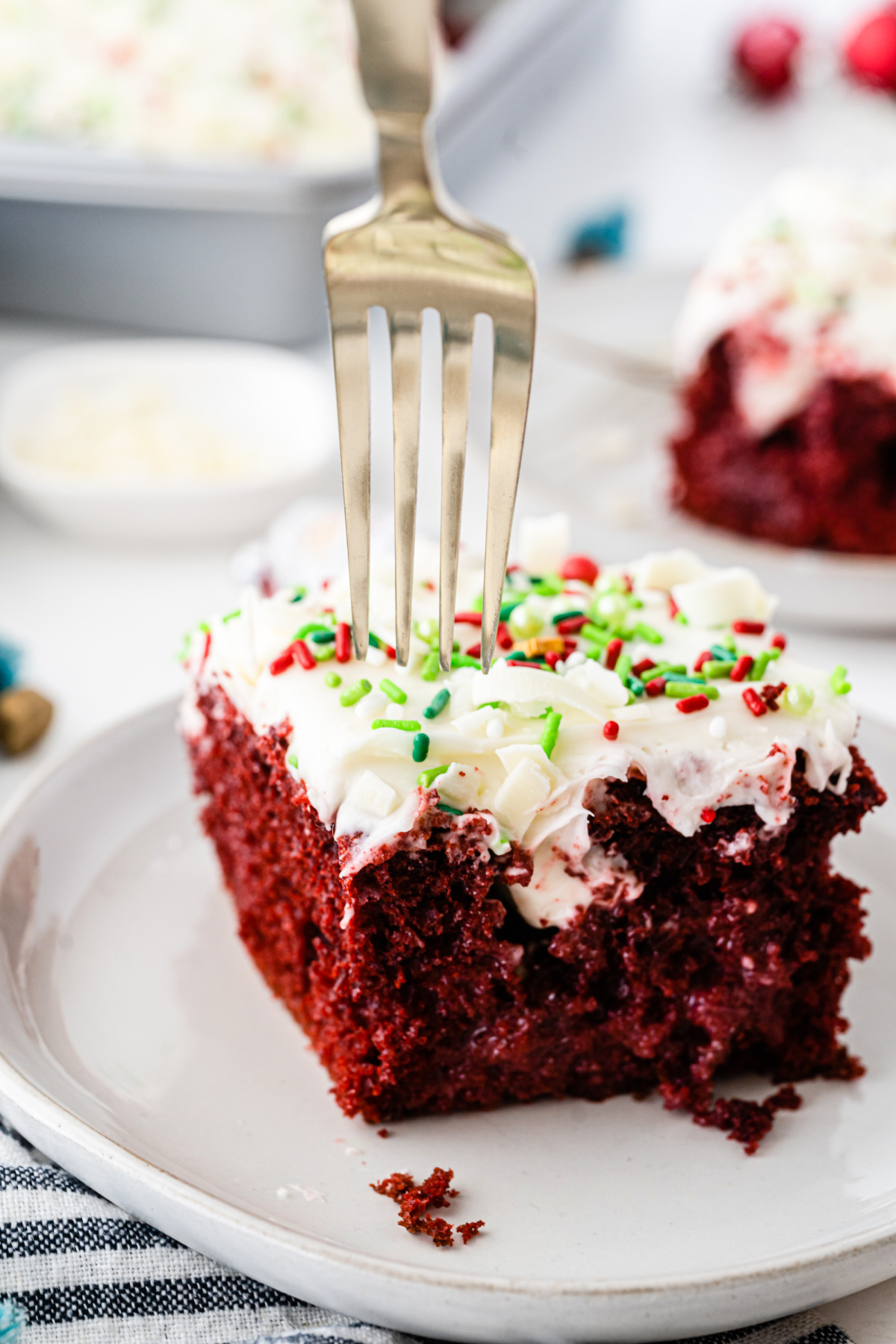 A slice of red velvet cake on a plate with a fork.