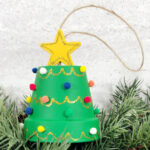 A green christmas tree ornament with a star on it.