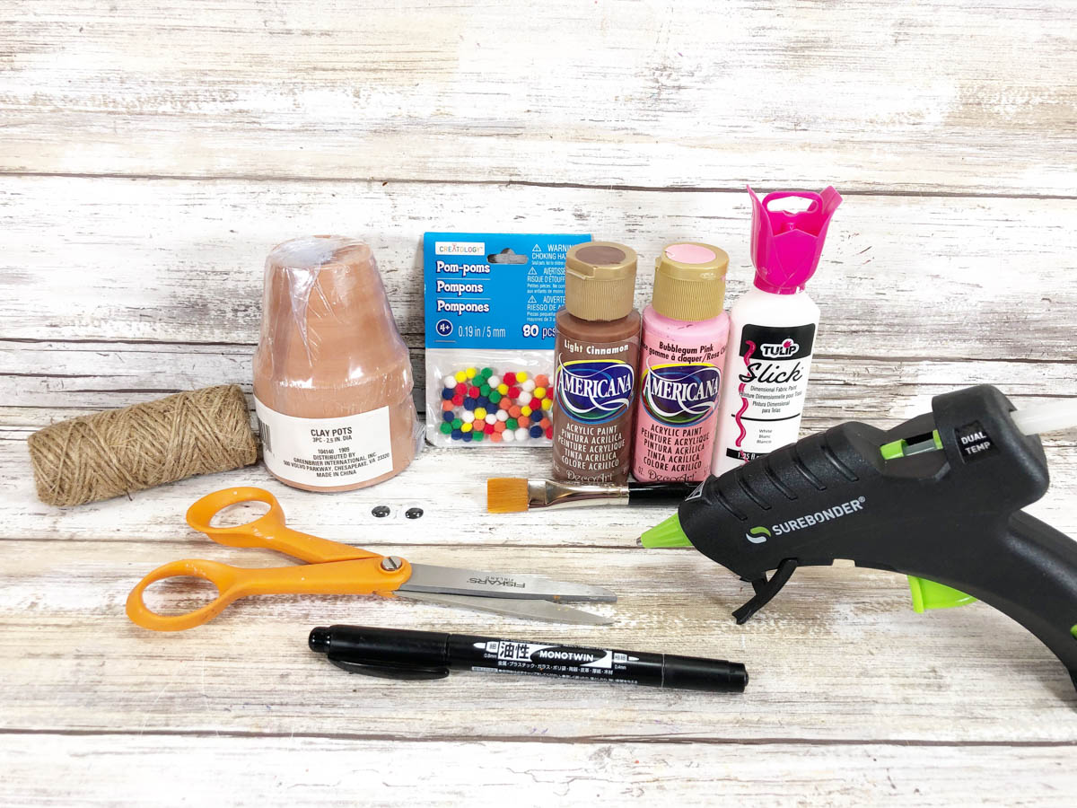 A table with a glue gun, scissors, and other craft supplies.