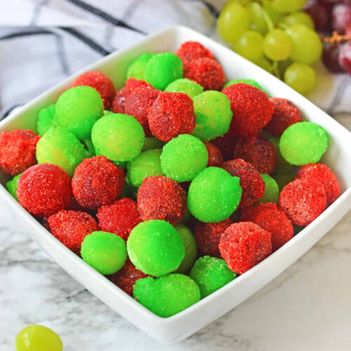 Red and green grapes in a white bowl.
